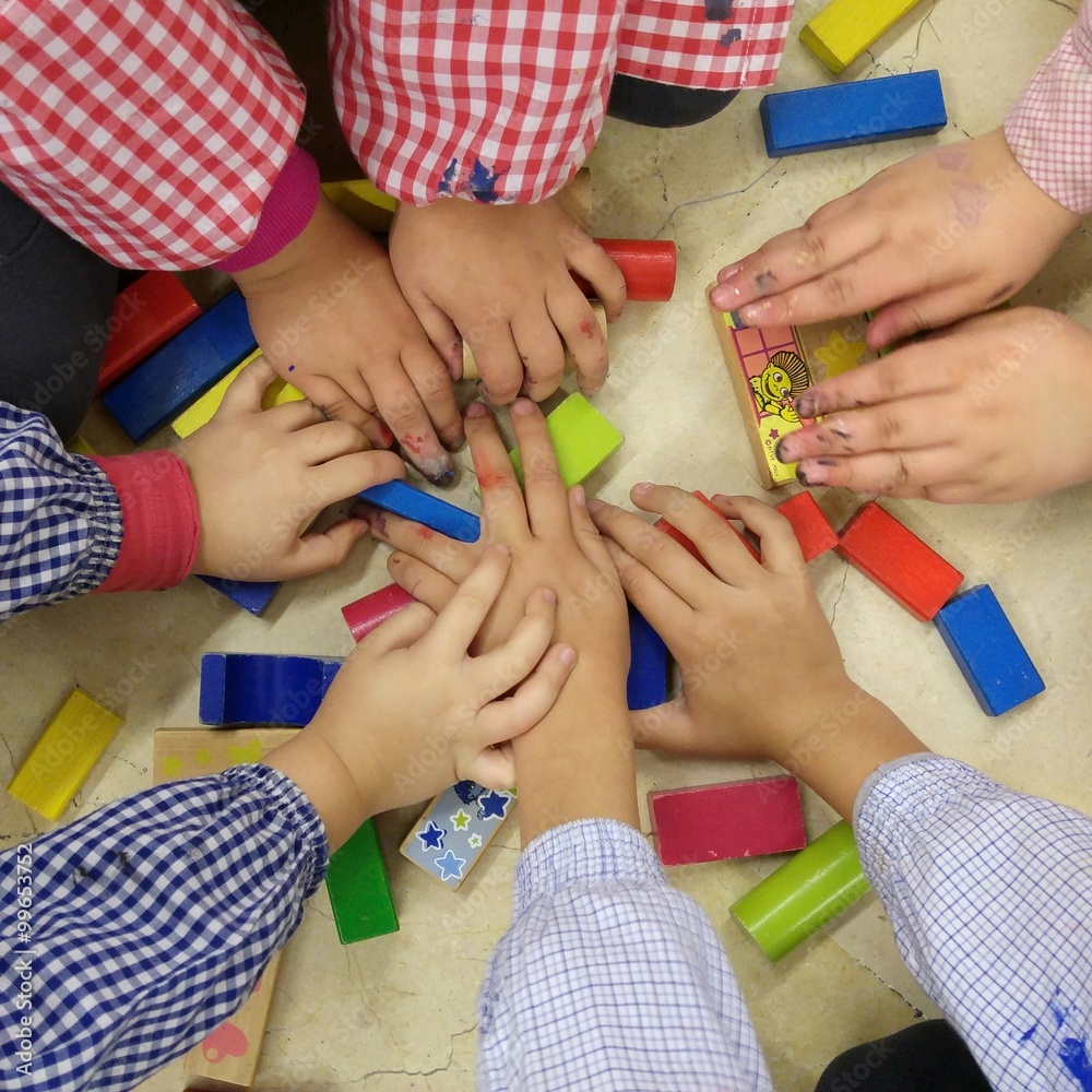 Manos de niños jugando con madera de colores foto de Stock | Adobe Stock