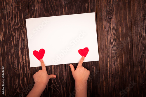 white sheet of paper little red hearts  wooden background photo