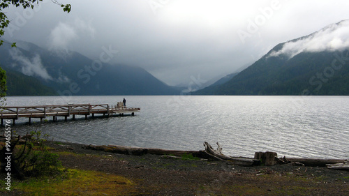 Foto Crescent Lake - A fisherman stands at the end of a dock as clouds descend from the mountains around Crescent Lake in Olympic National Park