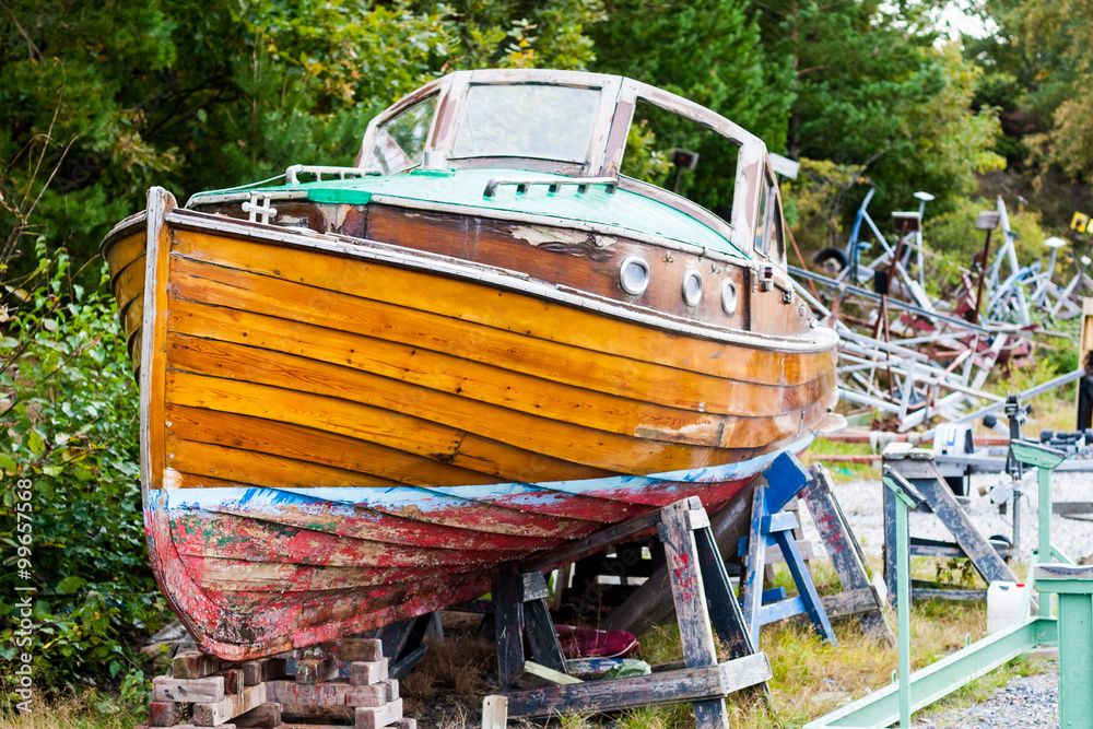 A beautiful old wooden boat is up on land for repairs in a dry dock. Location: Sweden.
