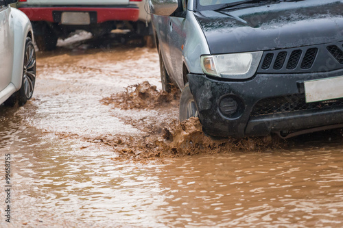mud splash by a car as it goes through flood water