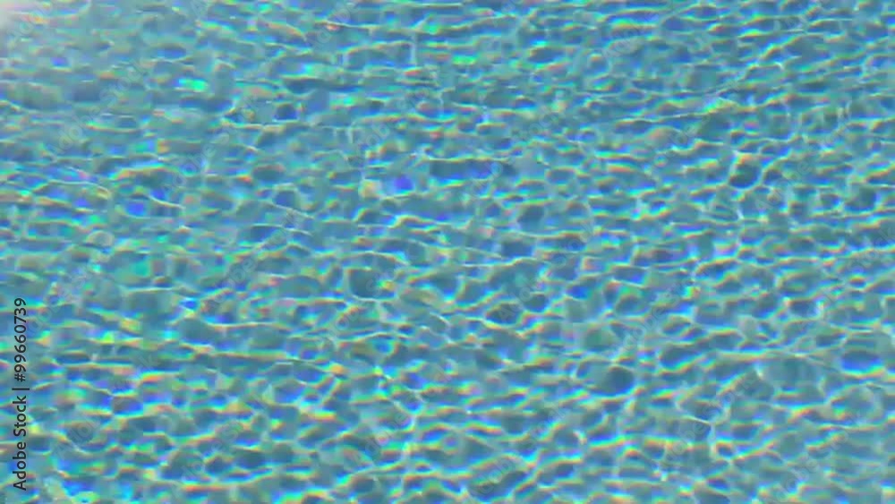 Blue swimming pool water reflecting the sunlight. High definition motion texture background.
