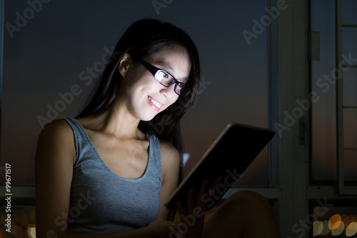 Woman use of the digital tablet at night