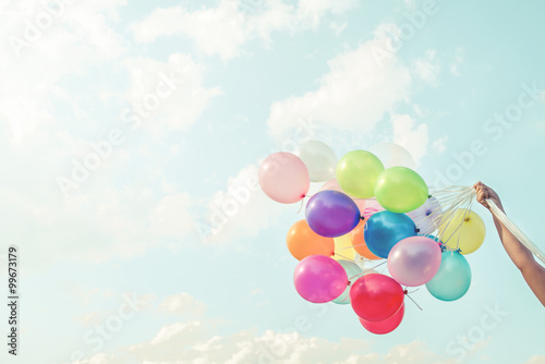 Tablou canvas Girl hand holding multicolored balloons done with a retro vintage instagram filt
