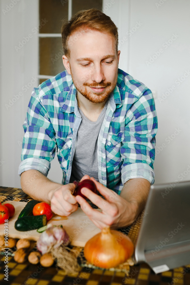 Fototapeta premium Young man cooking in home kitchen