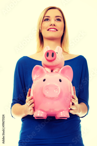 Happy woman holding two piggybanks.