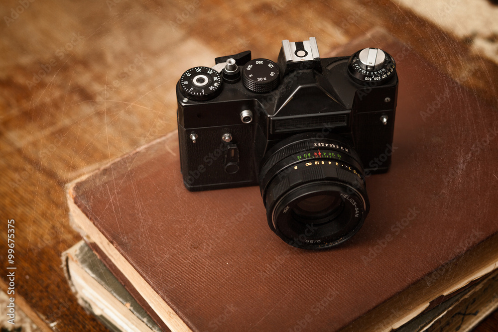 Old retro camera with photo on vintage grunge wooden boards