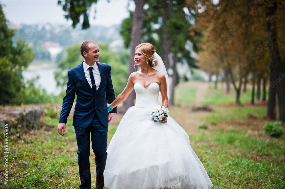 Married walking in the rain at park Married walking in the rain at park