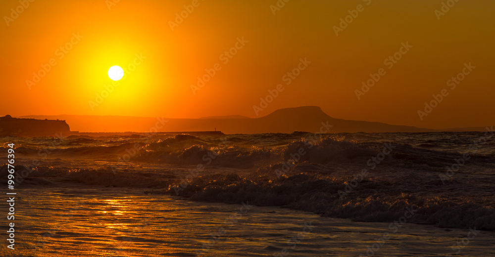 Fototapeta premium A beautiful beach on a Greek island in summer, under warm sunset light