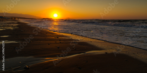 Fototapeta Naklejka Na Ścianę i Meble -  A beautiful beach on a Greek island in summer, under warm sunset light
