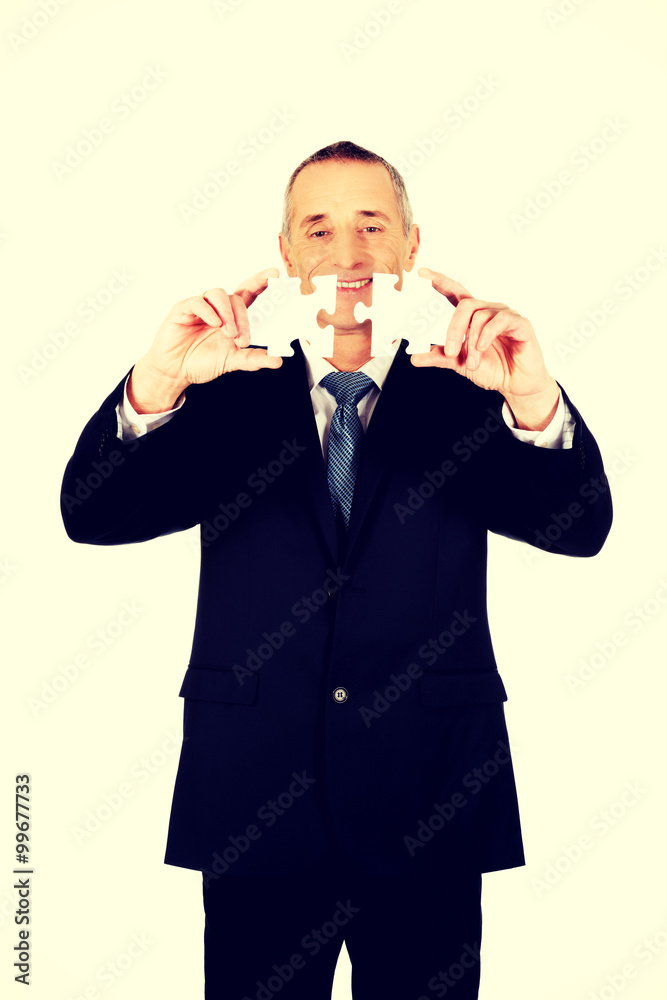Businessman trying to connect puzzle pieces. Businessman trying to connect puzzle pieces.