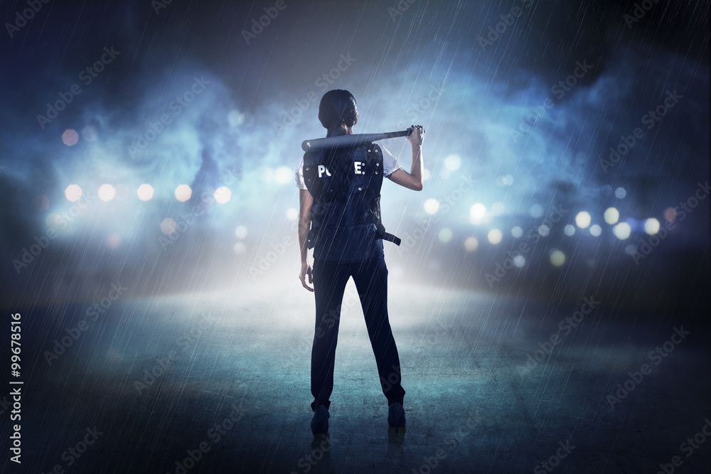 Pretty woman in police vest holding baseball bat Pretty woman in police vest holding baseball bat