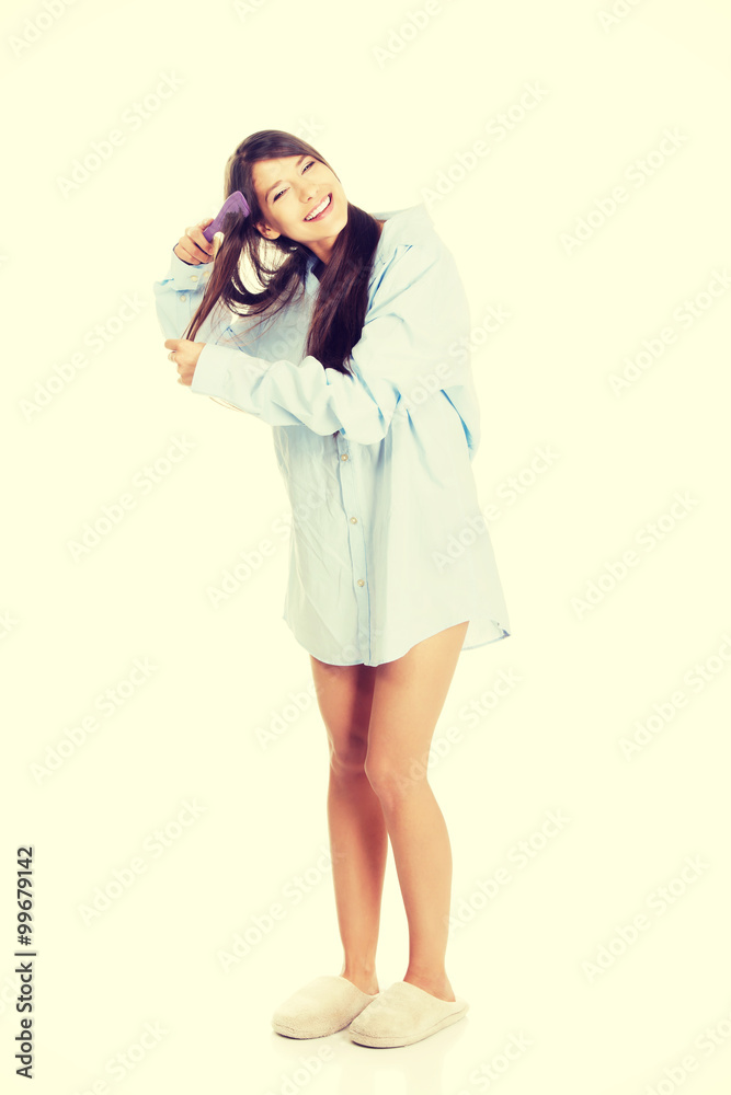 Morning woman in big shirt combing hair. Morning woman in big shirt combing hair.