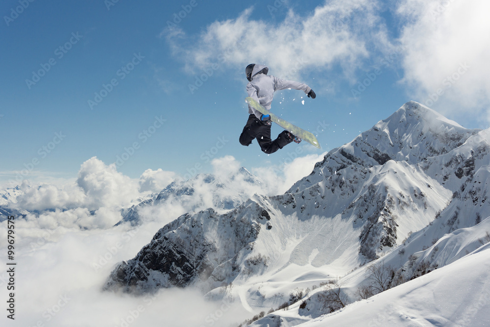 Flying snowboarder on mountains. Extreme sport.