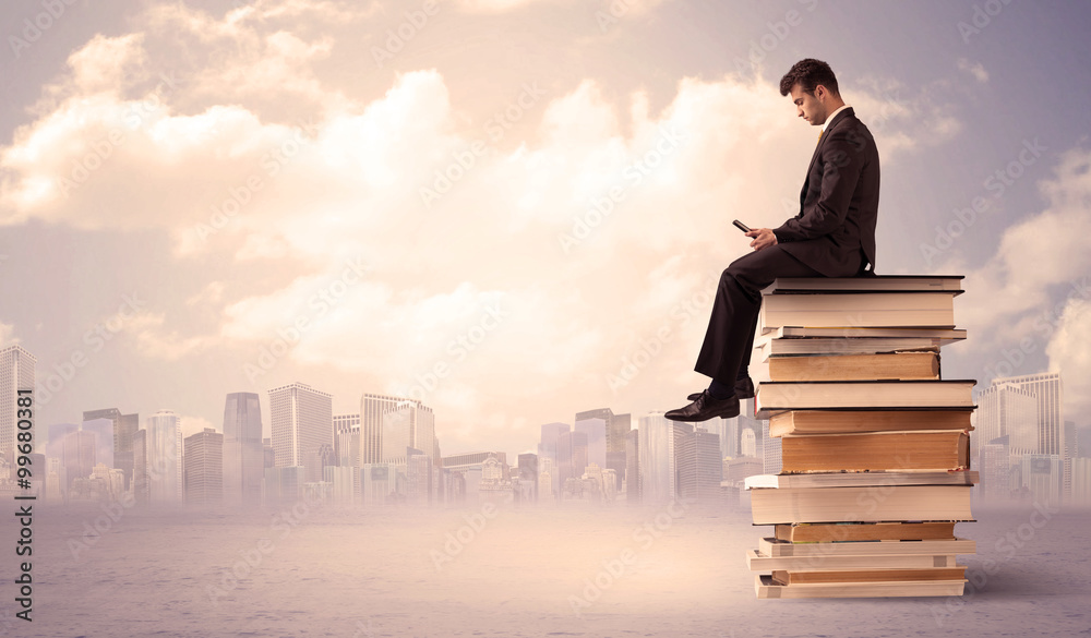 businessman with laptop sitting on books businessman with laptop sitting on books