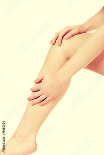 Woman massaging her leg. © Piotr Marcinski