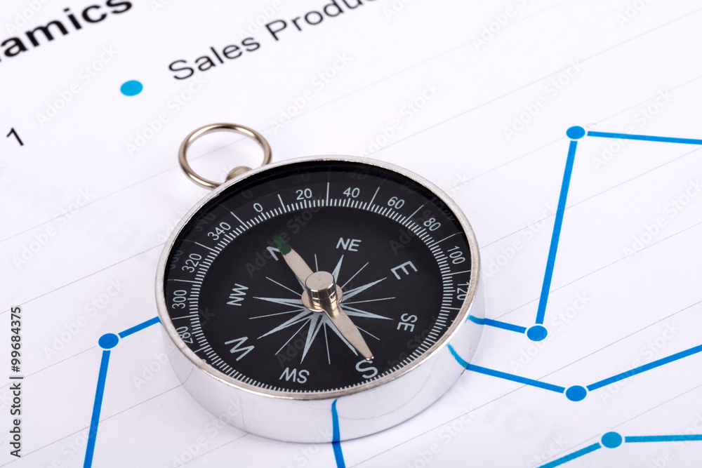 Business concept with compass and graph on paper Business concept with compass and graph on paper