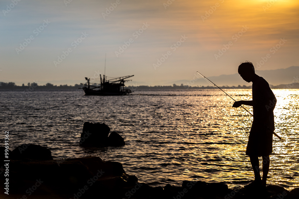 silhouette of a fisherman at the coastline