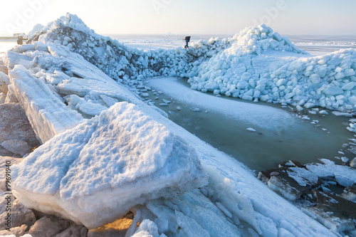Fotografie Man sneaks past the frozen sea ice hummocks