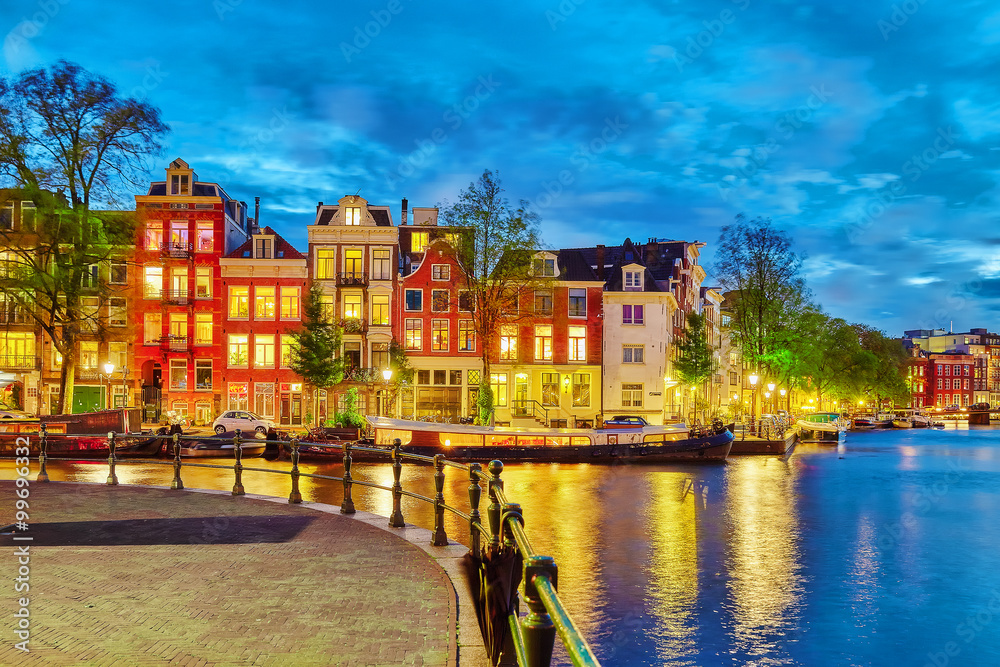 Famous Amstel river and night view of beautiful Amsterdam city.