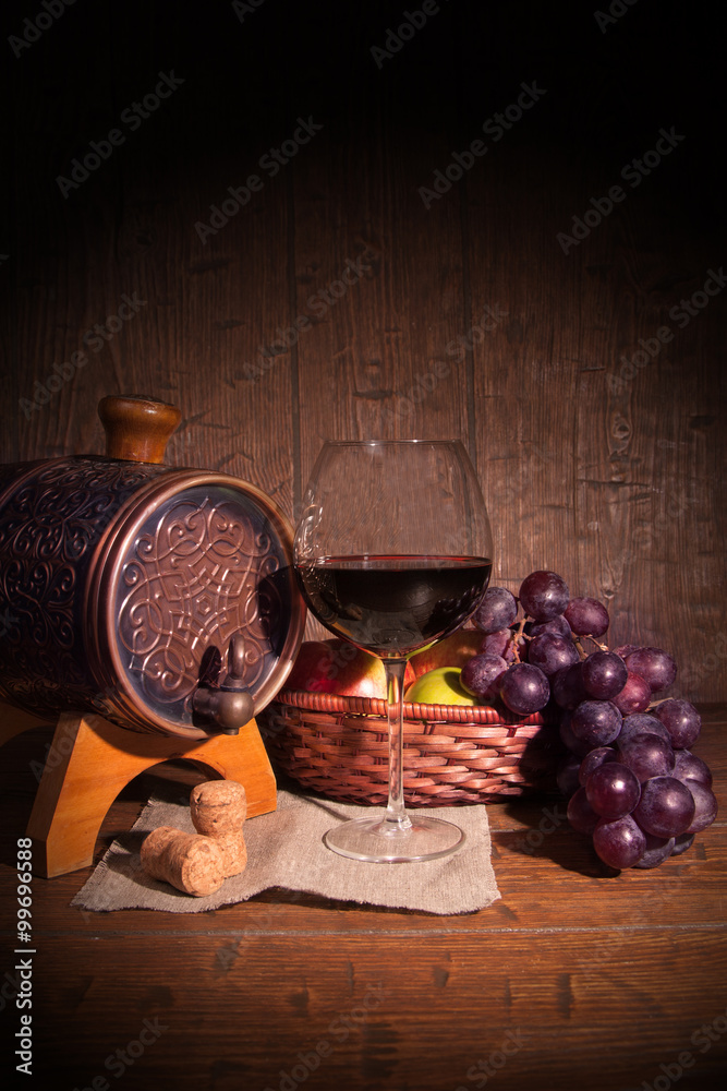 Glass of red wine and barrel on rustic wood tabel