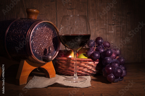 Fototapeta Naklejka Na Ścianę i Meble -  Glass of red wine and barrel on rustic wood tabel