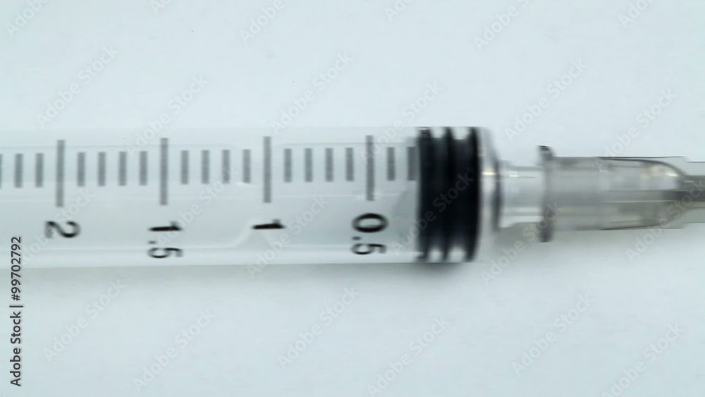A syringe lying on a white table A syringe lying on a white table