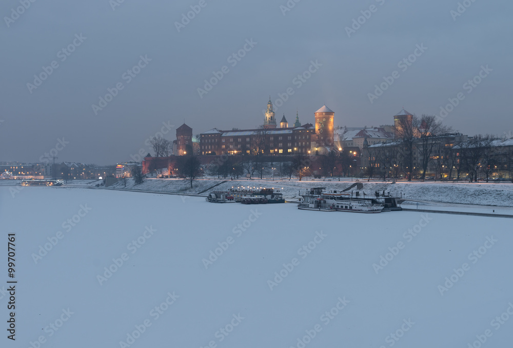 Royal castle on the Wawel hill, Krakow, Poland, over frozen Vistula river, winter evening