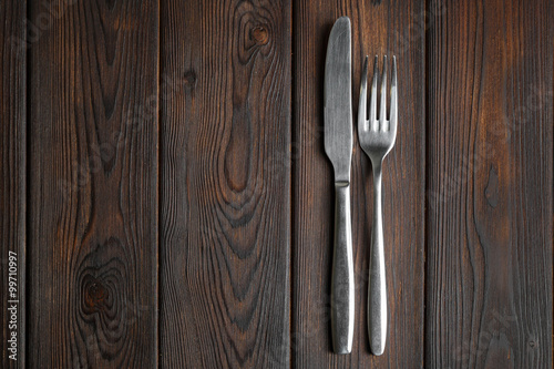 Fork and knife on dark wood background