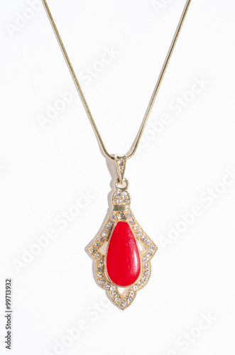 Indian gold pendant with red gem on a white background