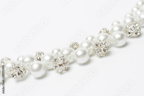 Pearl necklace with diamonds on a white background