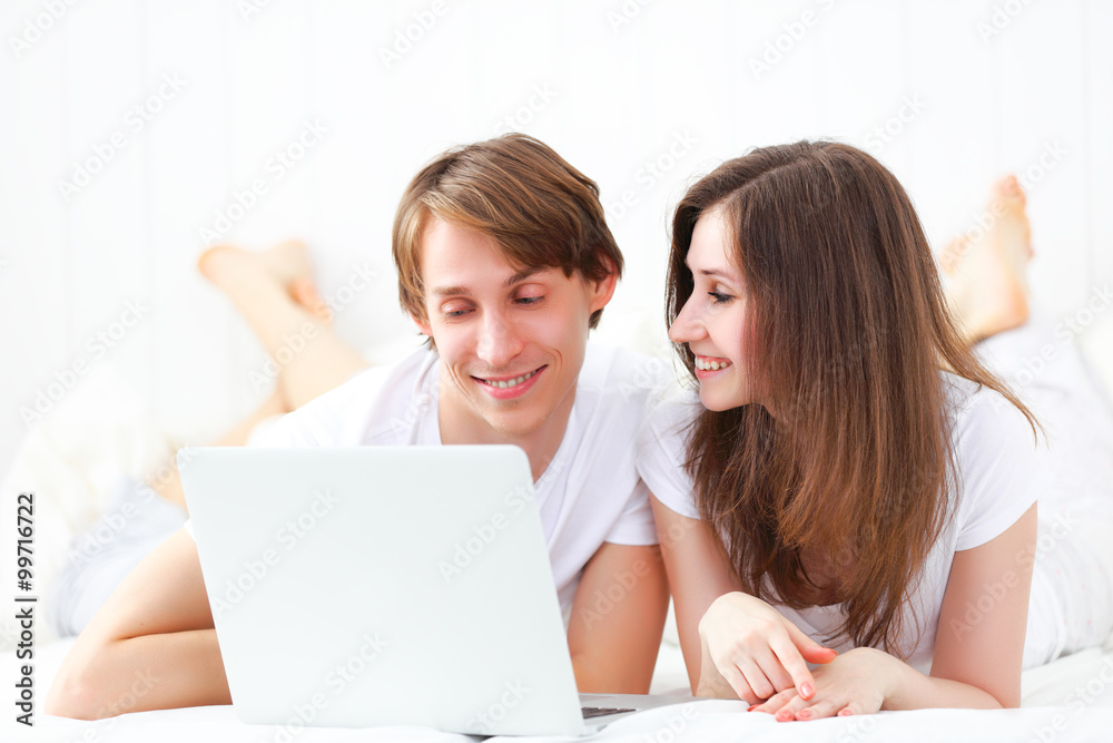 happy couple with laptop on internet in bed happy couple with laptop on internet in bed