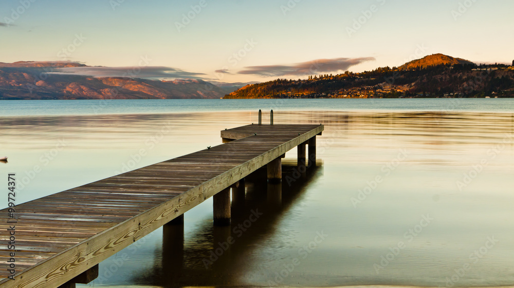 small boat dock on a still mountain lake at sunrise