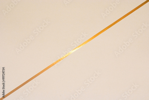 golden line on color paper background - abstract graphic design