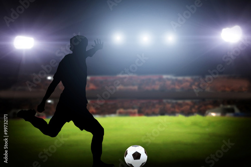 silhouette of a player shooting football on goal. Lights on the © tuiphotoengineer