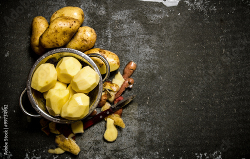 The concept of wet peeled potatoes on a stone background . Free space for text.