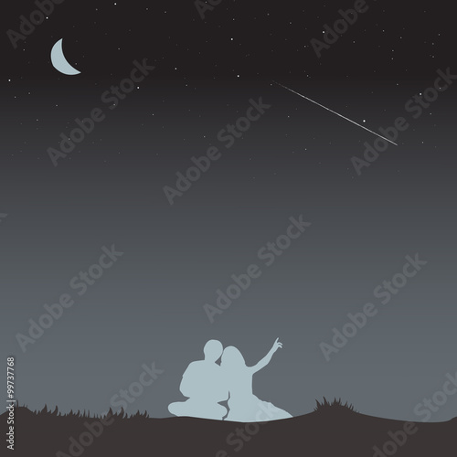 A couple sit on ground and point faraway to see a falling stars