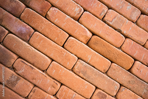 Grunge red brick wall background in slope view
