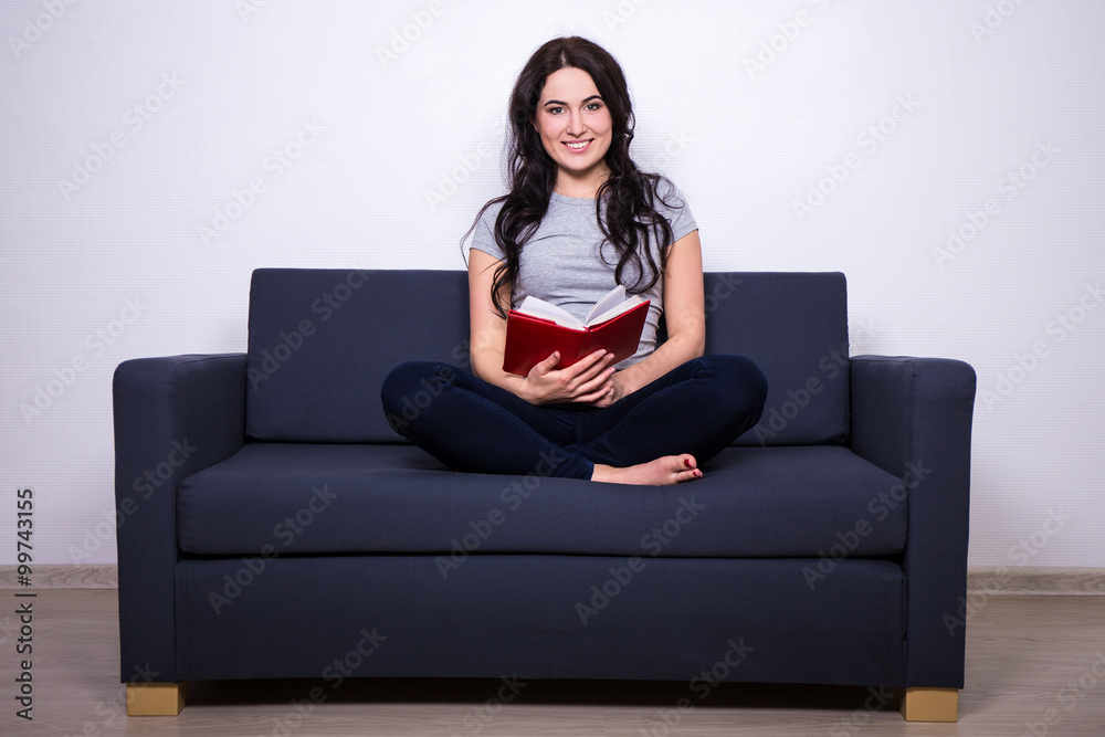 portrait of happy woman sitting on sofa and reading book portrait of happy woman sitting on sofa and reading book