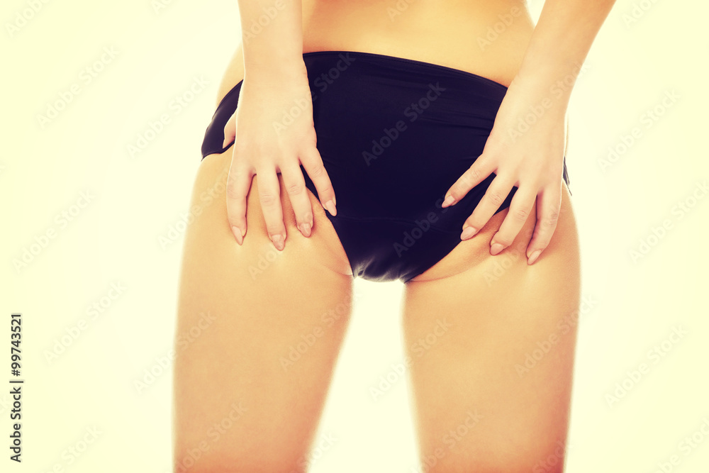 Woman touching her buttocks.