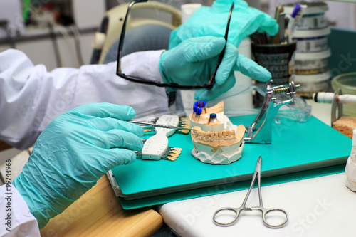 Dental technician checks his work in the lab