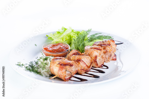 Skewers of beef and pork with parsley, onion and lettuce on a wh