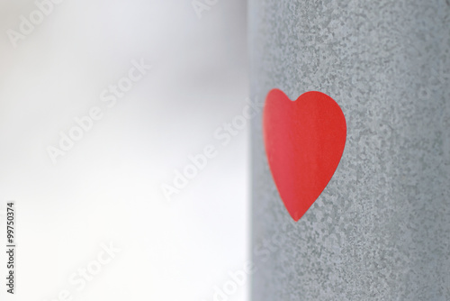 Red heart sticker on a lamp post during winter
