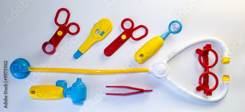 Toys medical tools made of plastic, view from top on white backg