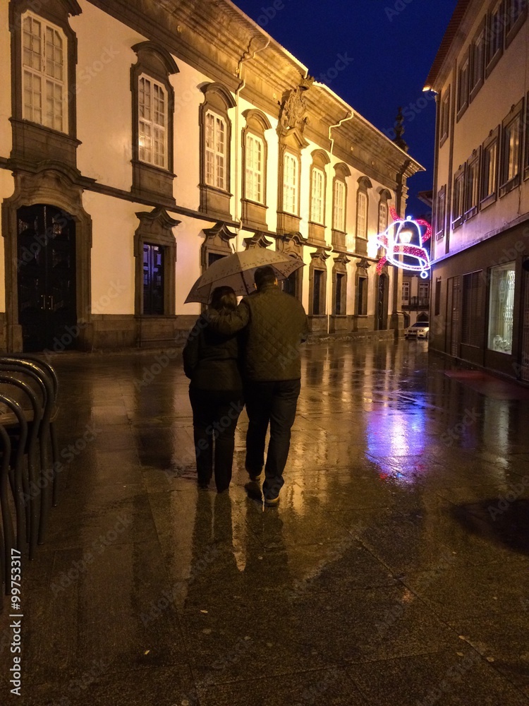 pareja paseando bajo la lluvia por la ciudad