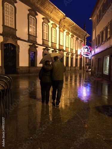 pareja paseando bajo la lluvia por la ciudad