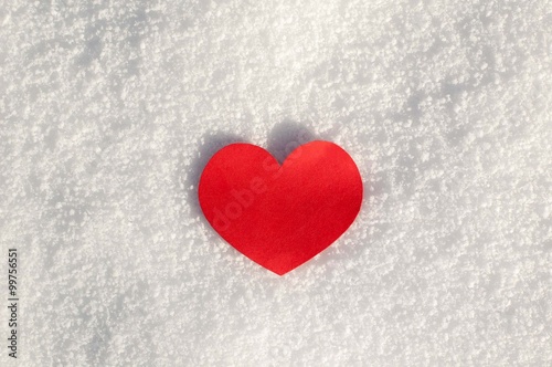Red paper hearts on the snow.