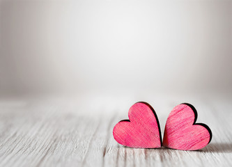 Valentines day background with two red hearts on wooden background