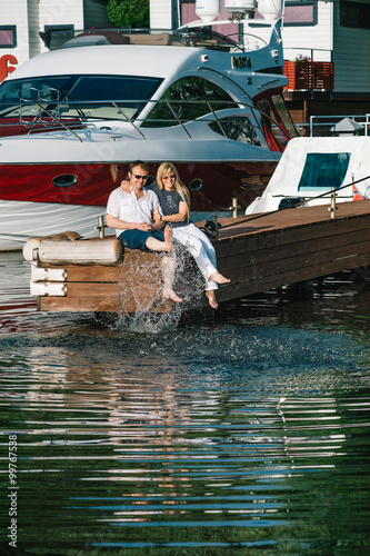 Man and woman relaxing on a berth in yacht club.