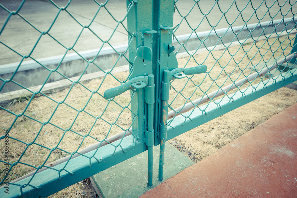 Green metal fence lock with pastel tone